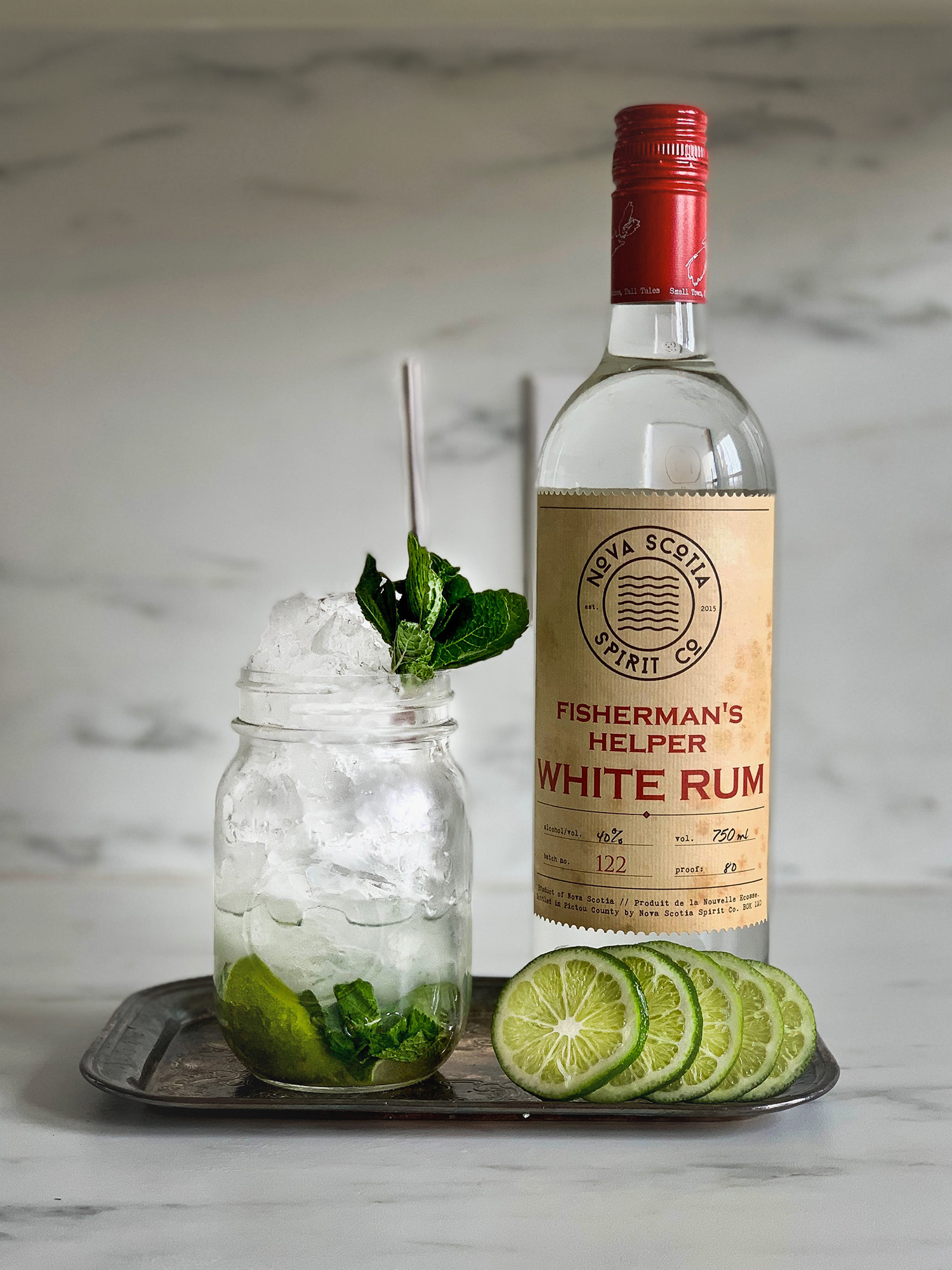 Go-Jito in mason jar beside Fisheman's Helper white rum with lime slices