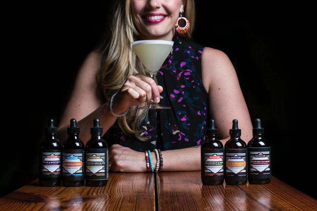 Lauren Mote with drink and Bittered Sling Bitters on table