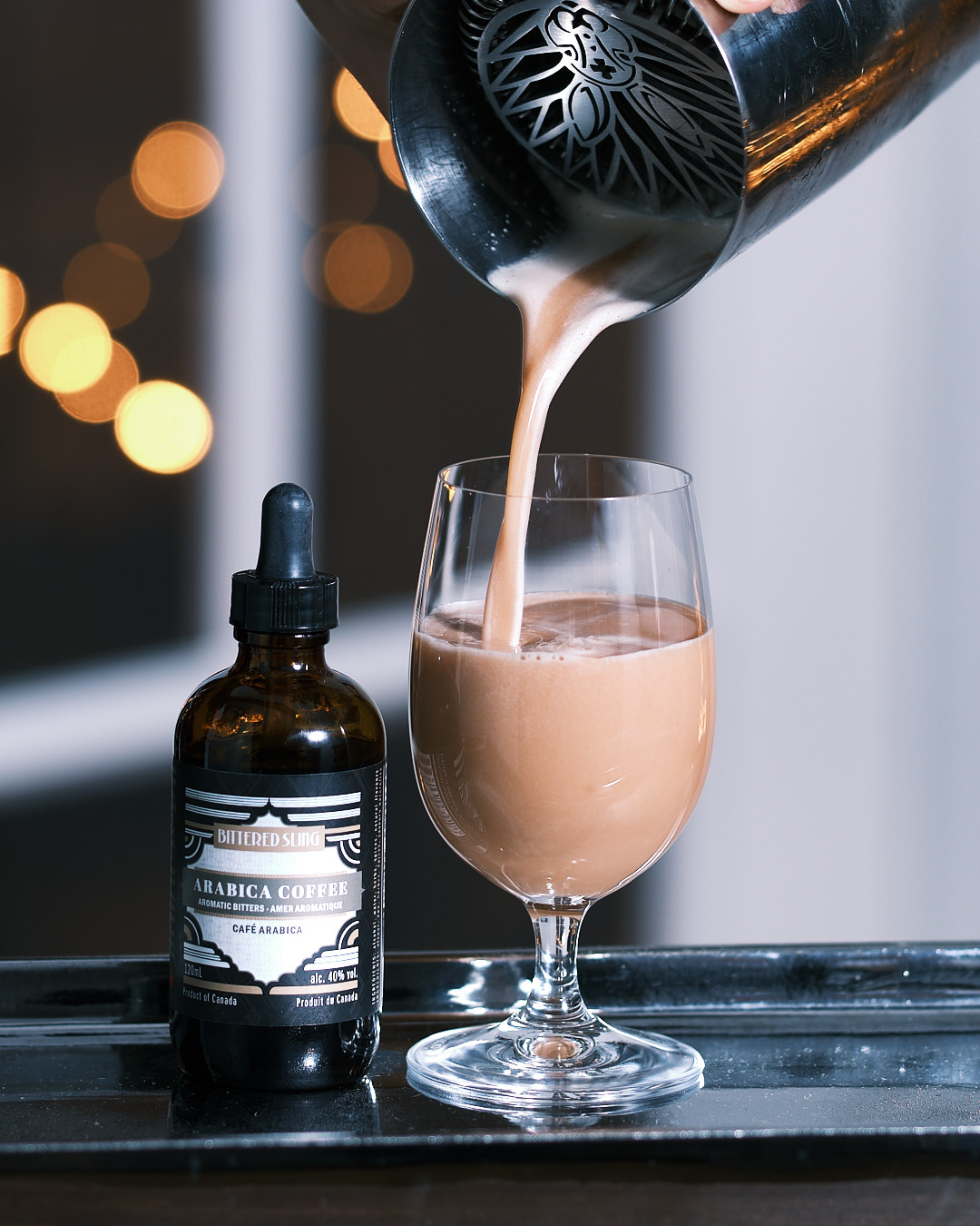 Negroni Flip being poured into a glass with Arabica Coffee bitters beside it